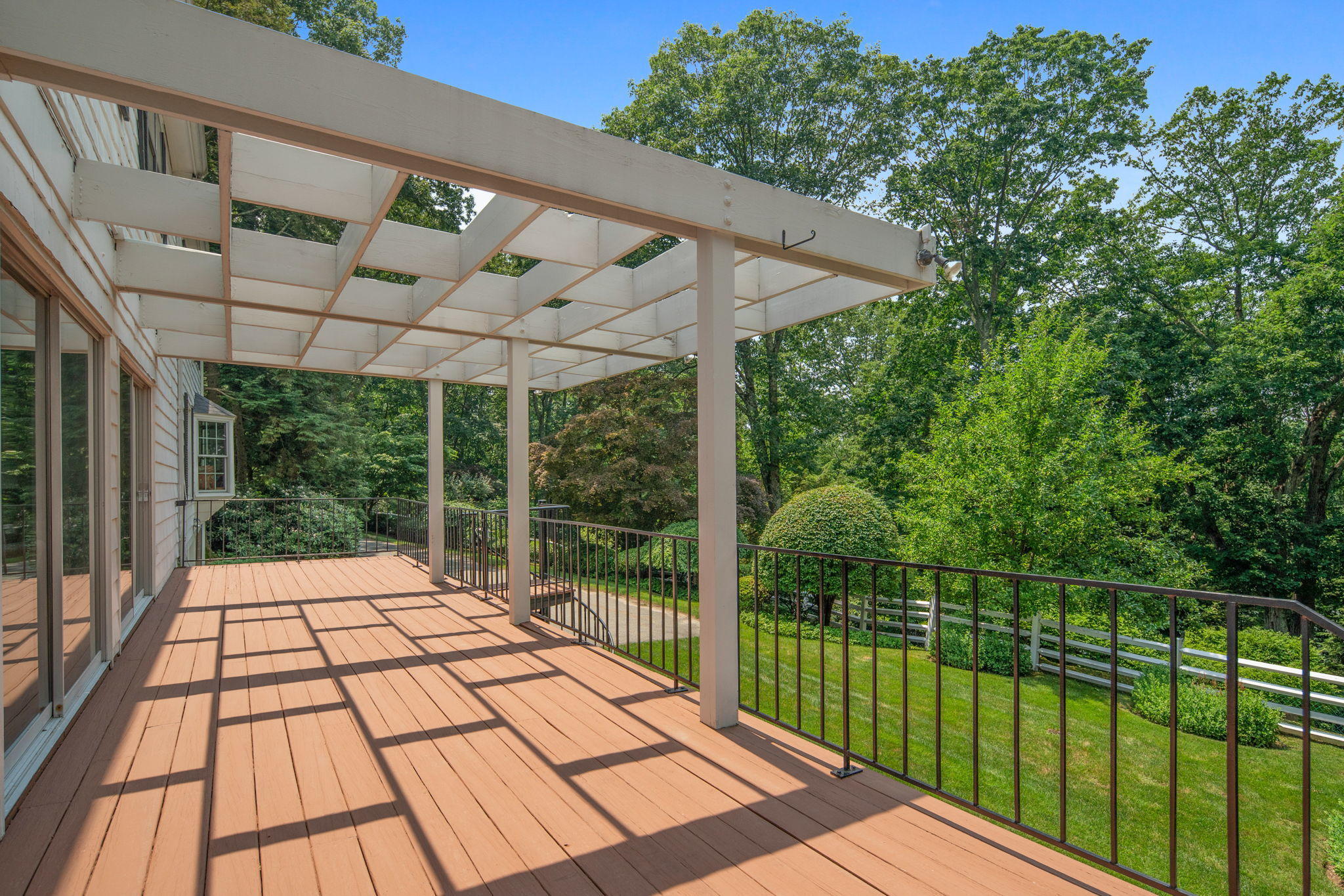 2061 Ponus Ridge Road New Canaan, CT 06840 - Photo 8 of 50 a view of a backyard with wooden floor and iron fence