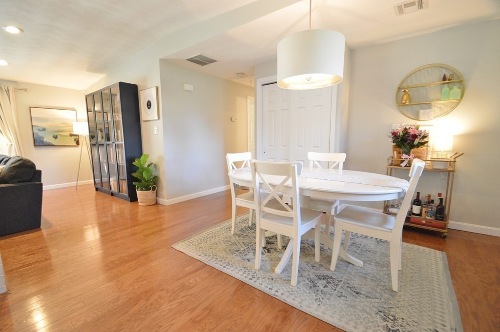 24 Raleigh Road Framingham, MA 01701 - Photo 15 of 37 a dining room with wooden floor a chandelier a wooden table and chairs