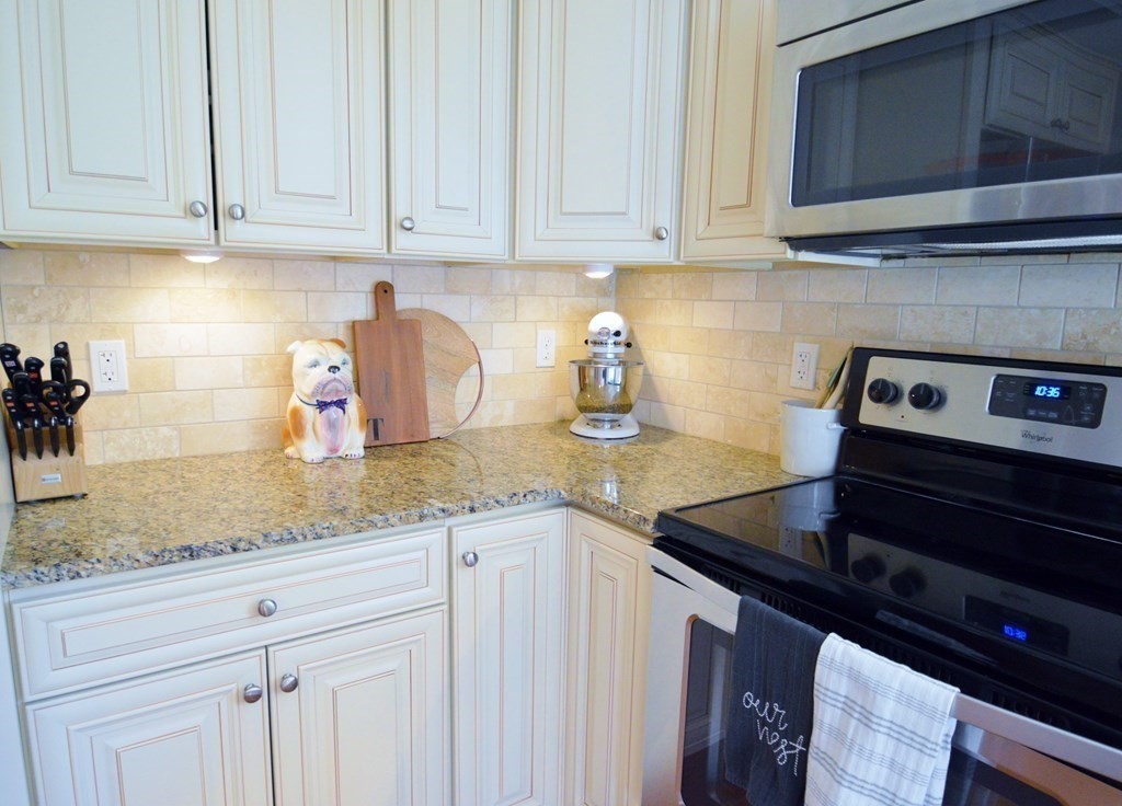 24 Raleigh Road Framingham, MA 01701 - Photo 4 of 37 a kitchen with granite countertop white cabinets and a stove