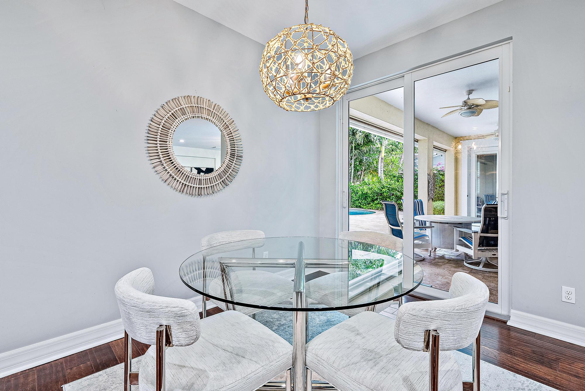 2702 West Mallory Boulevard Jupiter, FL 33458 - Photo 12 of 39 a view of a dining room with furniture a chandelier and wooden floor