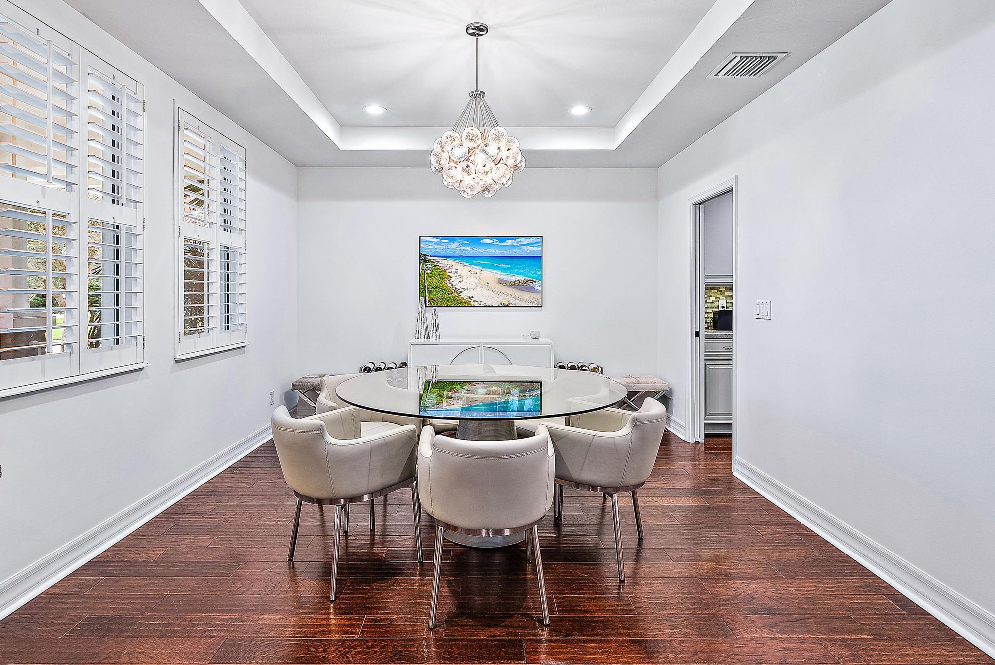 2702 West Mallory Boulevard Jupiter, FL 33458 - Photo 4 of 39 a view of a dining room with furniture wooden floor and chandelier