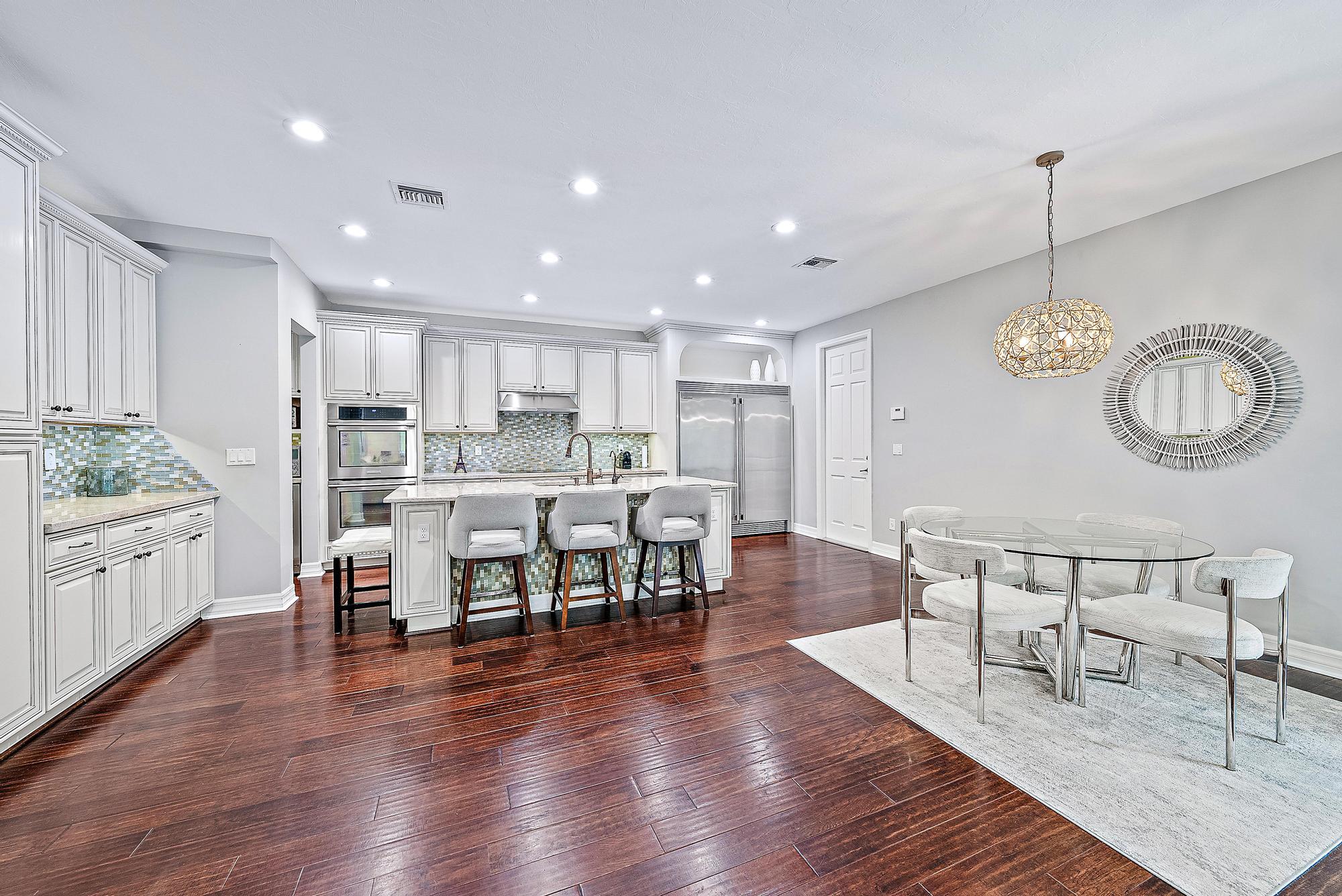 2702 West Mallory Boulevard Jupiter, FL 33458 - Photo 7 of 39 a view of a dining room with furniture a kitchen and chandelier