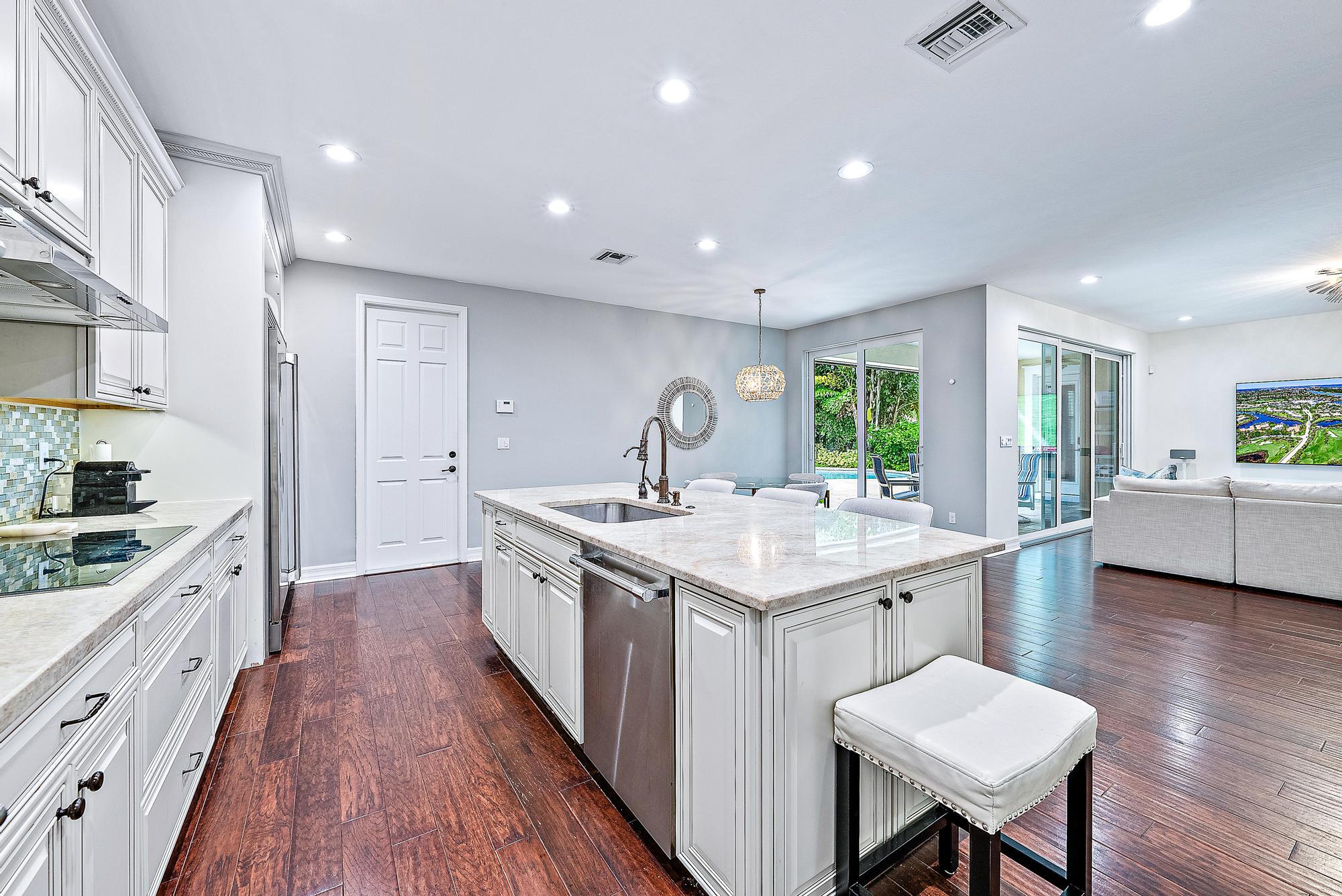 2702 West Mallory Boulevard Jupiter, FL 33458 - Photo 9 of 39 a kitchen with a sink and wooden cabinets