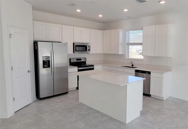 a kitchen with cabinets stainless steel appliances and window