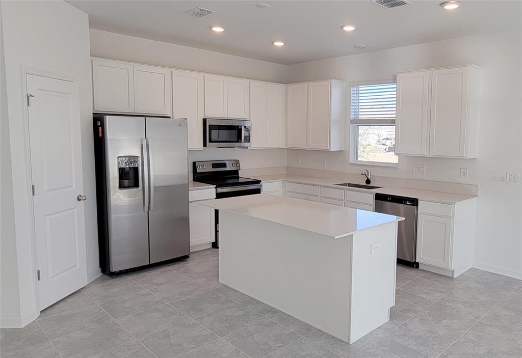 538 Hatteras Road Davenport, FL 33837 - Photo 3 of 29 a kitchen with cabinets stainless steel appliances and window