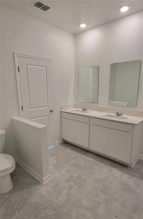 538 Hatteras Road Davenport, FL 33837 - Photo 10 of 29 a bathroom with a sink a toilet and a vanity