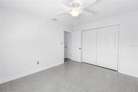 an empty room with a ceiling fan and a window