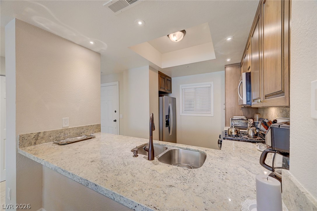 230 East Flamingo Road, Unit 106 Las Vegas, NV 89169 - Photo 8 of 66 A well-lit kitchen with granite countertops and stainless steel appliances awaits culinary adventures.