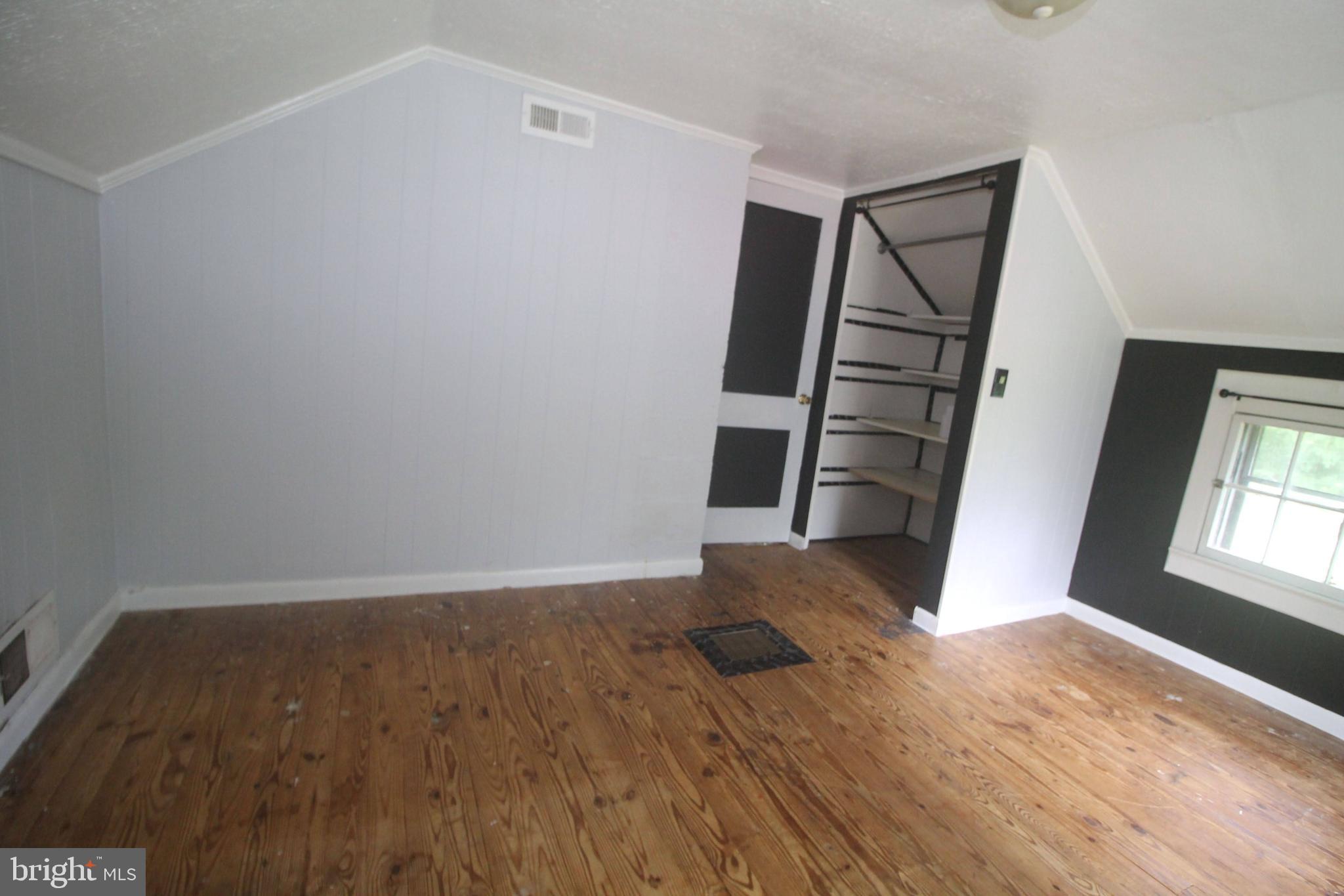 199 Keyser Run Road Washington, VA 22747 - Photo 23 of 30 an empty room with wooden floor and staircase