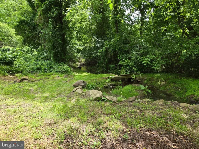 a view of green field with trees in the background