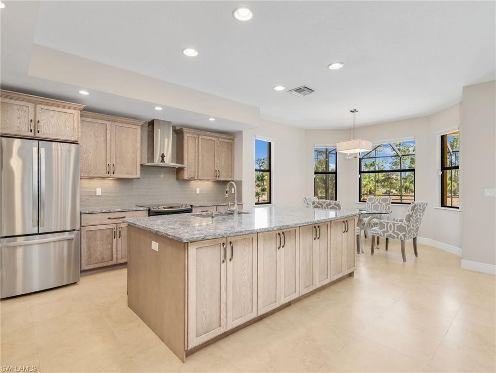 3160 27th Avenue Southwest Naples, FL 34117 - Photo 11 of 43 a white kitchen with stainless steel appliances granite countertop a stove and a refrigerator