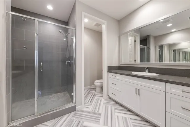 a spacious bathroom with a shower a sink and a mirror