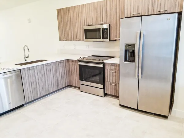 a kitchen with a refrigerator and a microwave
