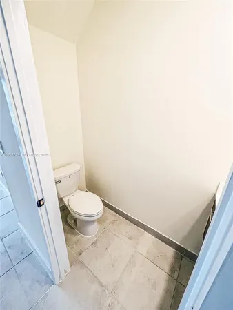 a white toilet sitting next to a shower