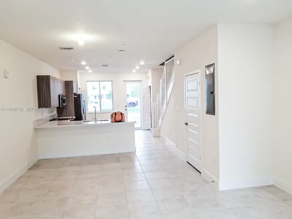 a view of kitchen with refrigerator and window