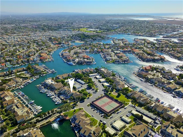 an aerial view of a city with lots of residential buildings ocean and mountain view in back