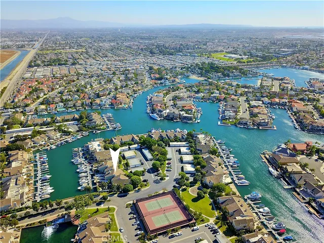 an aerial view of a city with lots of residential buildings and ocean view in back