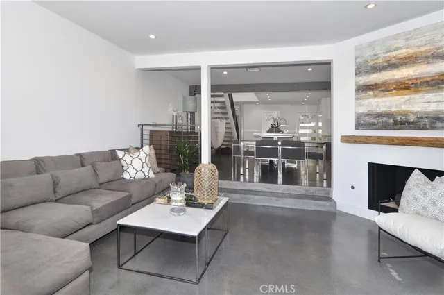 a living room with furniture a fireplace and a large window