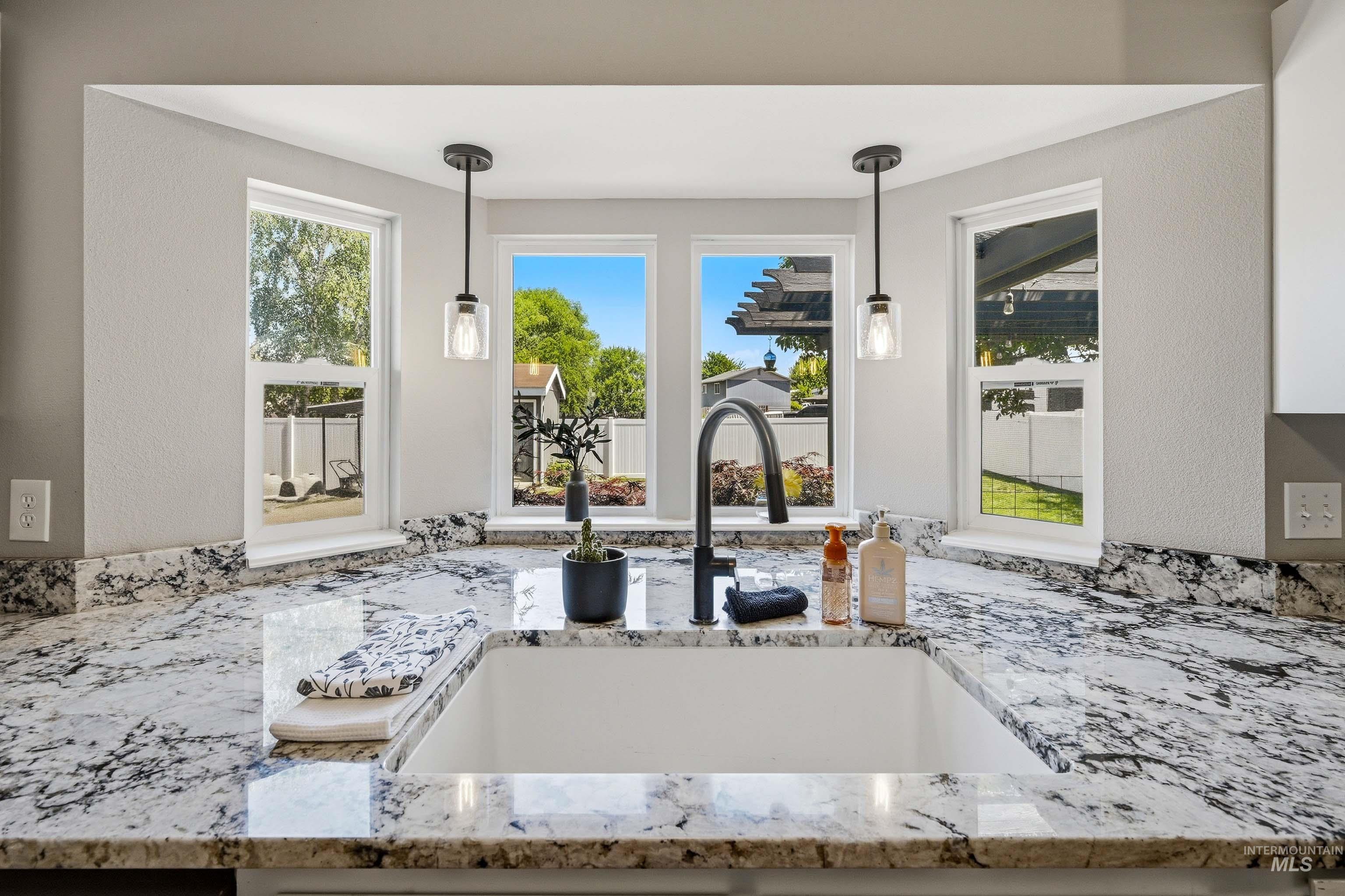 3715 18th Street Lewiston, ID 83501 - Photo 12 of 30 Kitchen sink area featuring a large single-basin sink with a matte black gooseneck faucet, set within patterned countertops