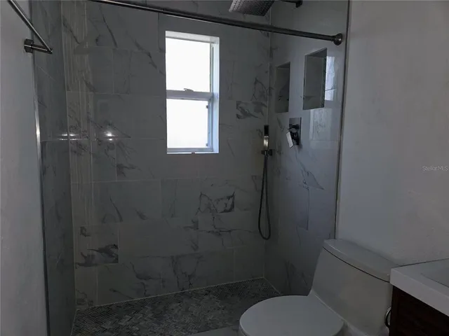 a bathroom with a toilet and a shower
