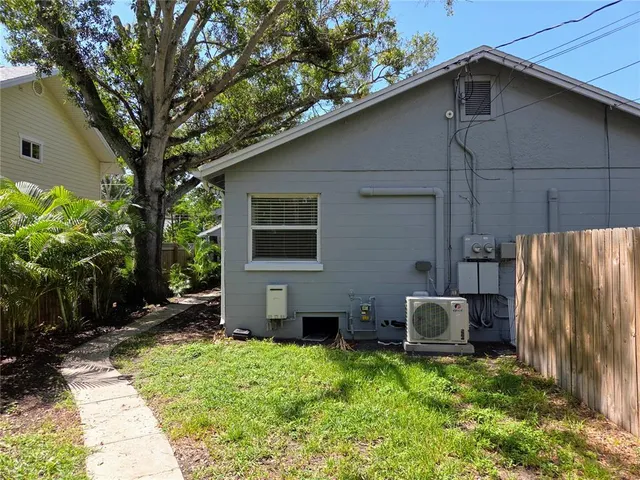 a backyard of a house with wooden fence and trees