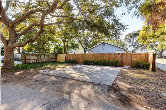 a view of a barn with wooden fence next to a road