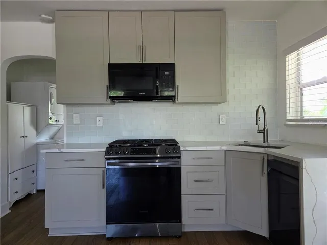 a kitchen with white cabinets stainless steel appliances and sink