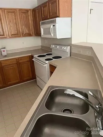 a kitchen with a sink and a stove with wooden roofs
