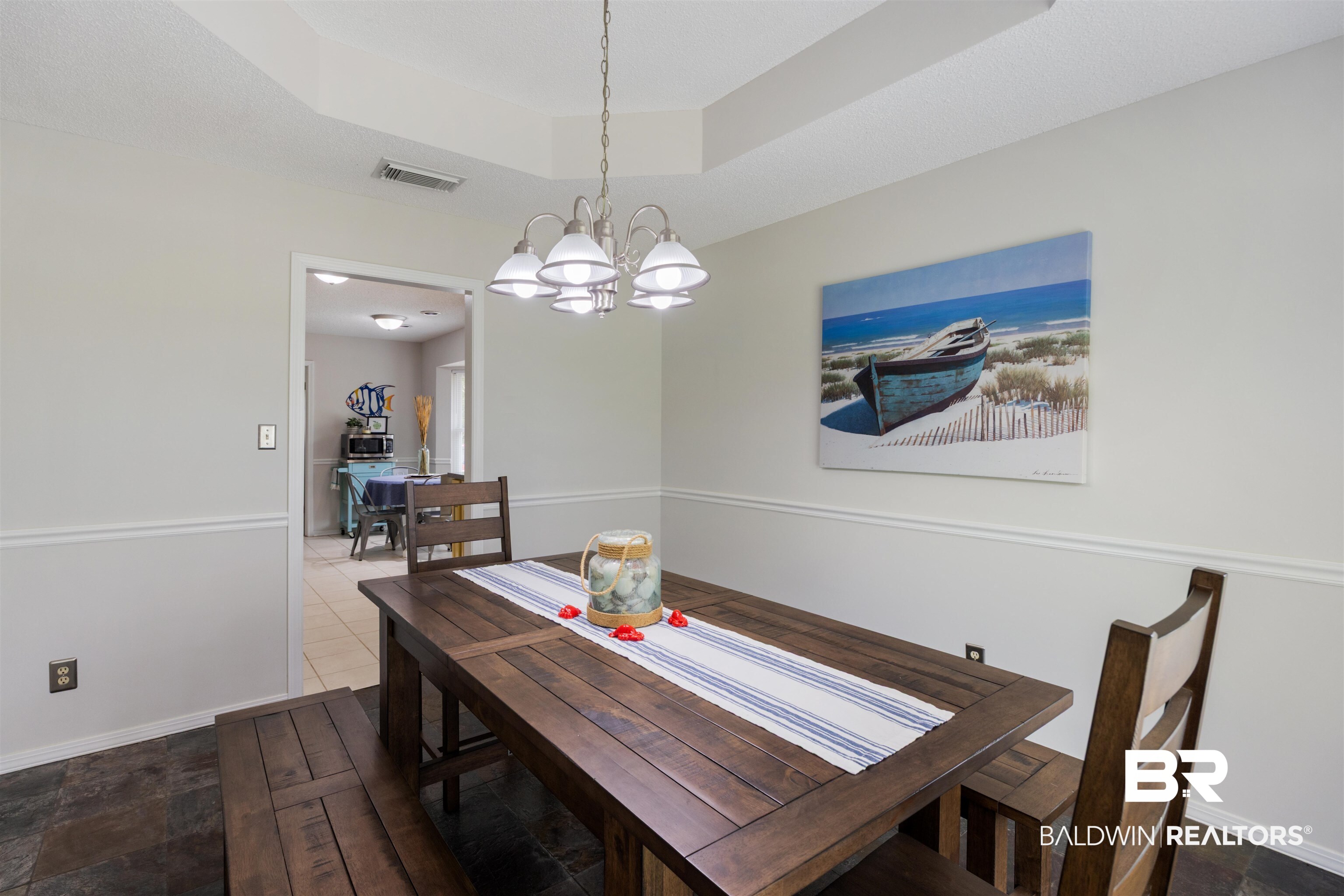9771 Clarke Ridge Road Foley, AL 36535 - Photo 36 of 72 Tiled dining area with baseboards, a raised ceiling, and a notable chandelier.