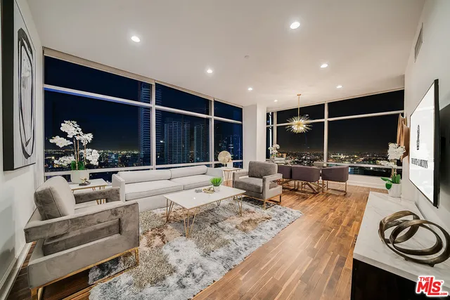 a living room with furniture a flat screen tv and a large window