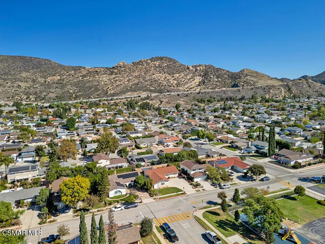 an aerial view of residential houses with outdoor space and parking