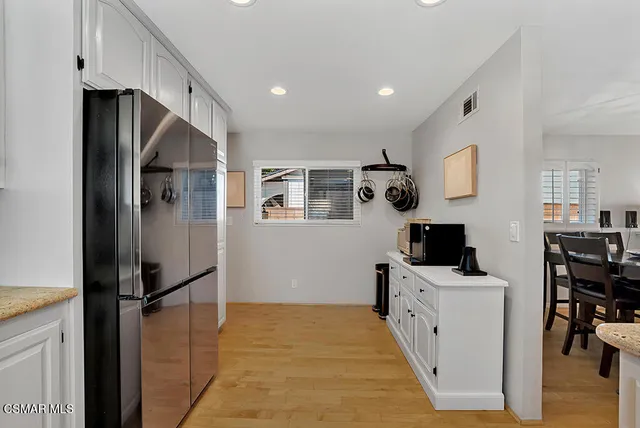a hallway with stainless steel appliances a refrigerator and a stove top oven