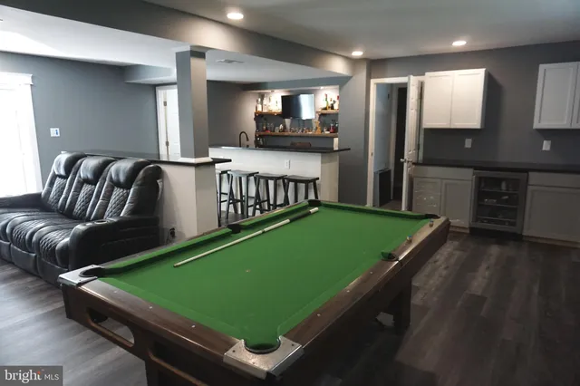 a room with pool table and windows