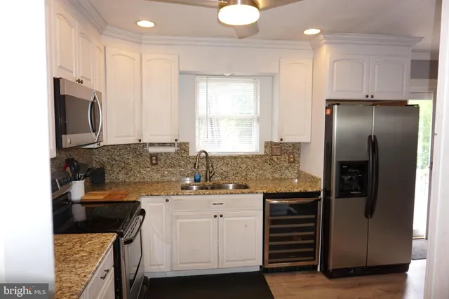 a kitchen with stainless steel appliances granite countertop a sink stove and cabinets