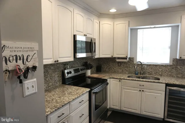 a kitchen with stainless steel appliances kitchen island granite countertop a refrigerator and a stove top oven