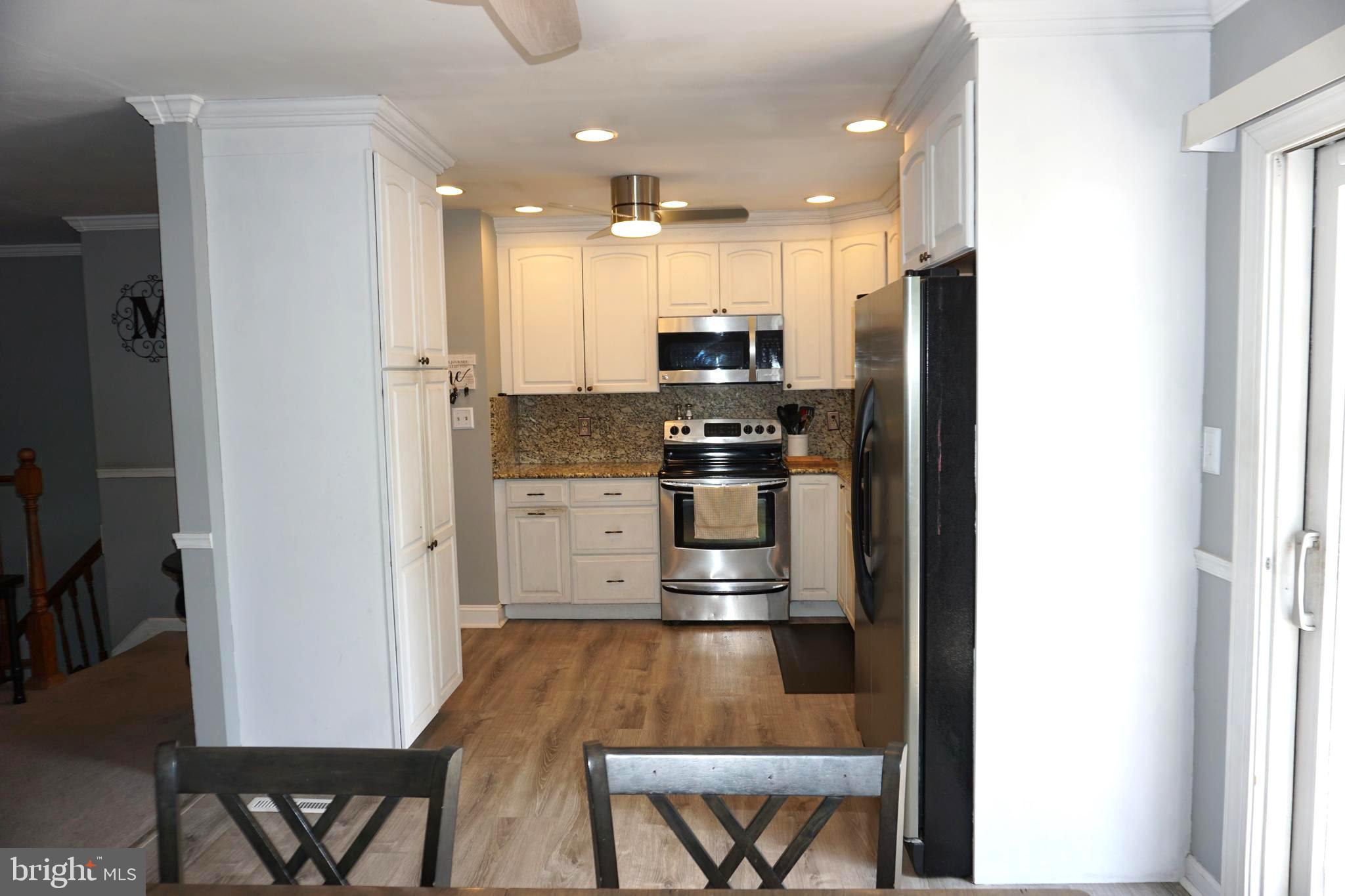8610 Oak Road Sparrows Point, MD 21219 - Photo 15 of 59 a kitchen with stainless steel appliances kitchen island granite countertop a refrigerator and a stove top oven
