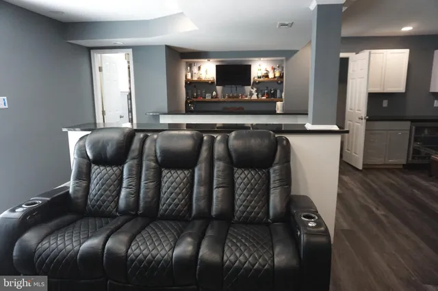a view of a backyard with table and chairs potted plants and large tree