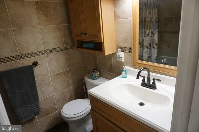 a bathroom with a sink a toilet and shower curtain
