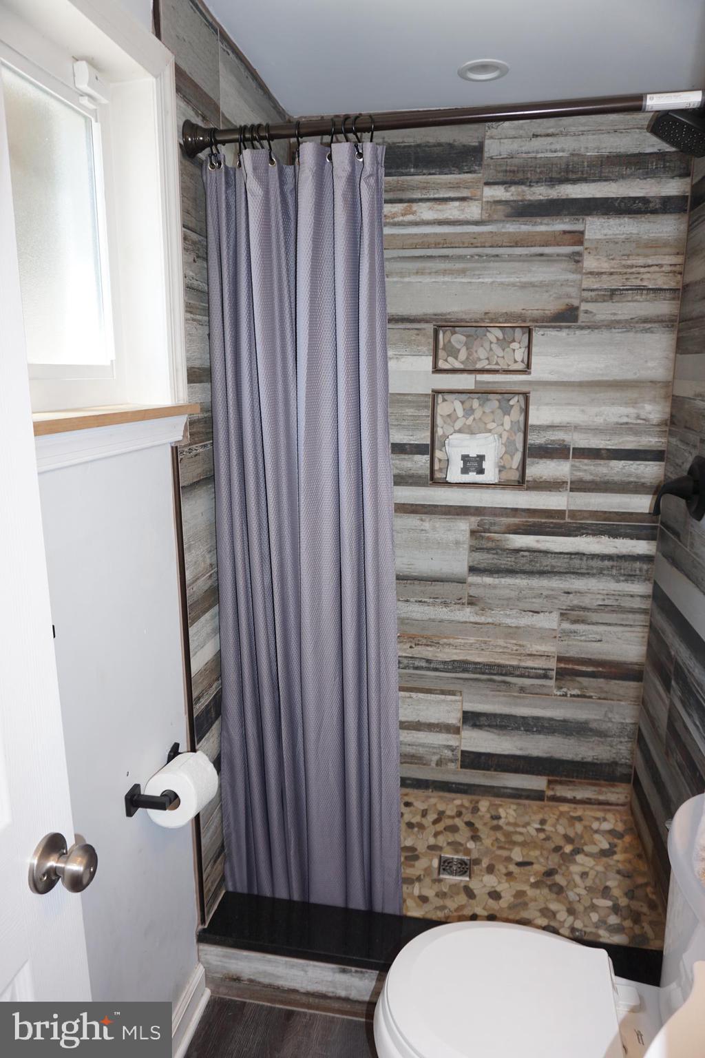 8610 Oak Road Sparrows Point, MD 21219 - Photo 53 of 59 a bathroom with a toilet and a shower curtain