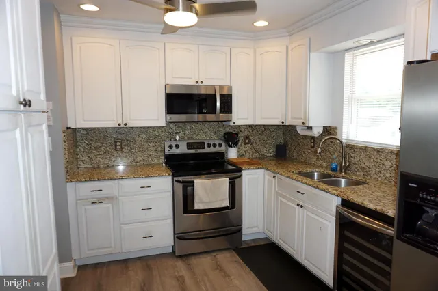 a kitchen with stainless steel appliances granite countertop a sink a stove and a microwave