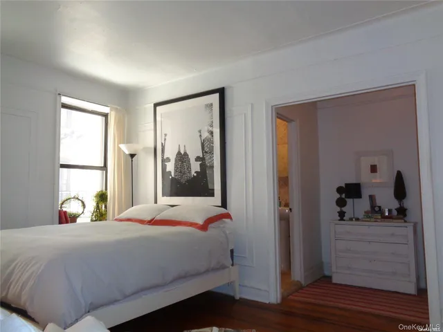 a bedroom with a bed a window and walk in closet