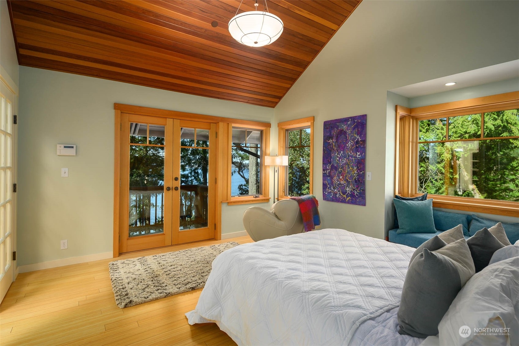 13629 Burma Road Southwest Vashon, WA 98070 - Photo 18 of 39 a bedroom with a large bed and large windows