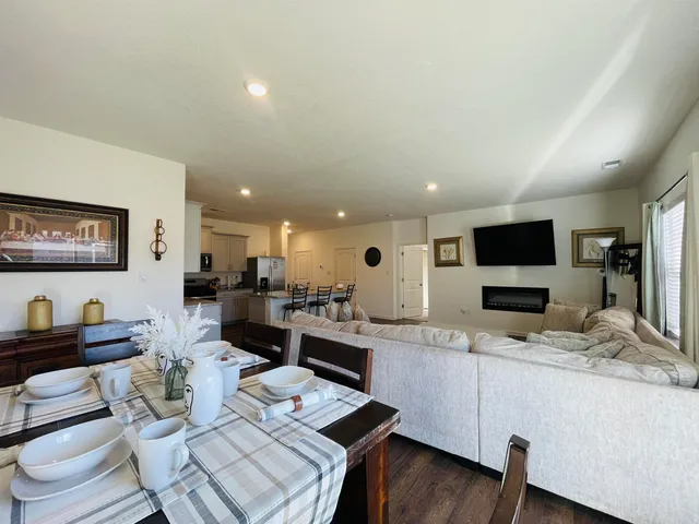 a kitchen with stainless steel appliances a stove a sink a refrigerator white cabinets and couches