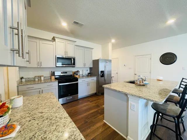 a kitchen with a stove a refrigerator and a sink