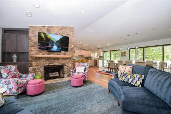 a living room with furniture flat screen tv and kitchen view