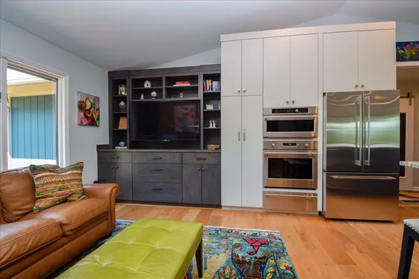 a bedroom with a bed a dresser and painting on the wall