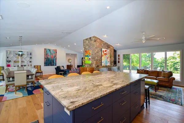 a bathroom with a granite countertop sink and a large window
