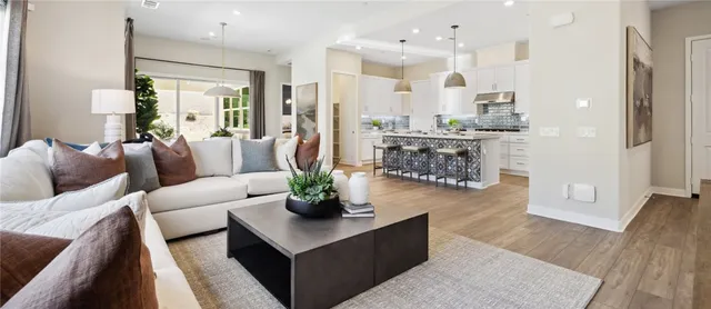 a living room with furniture and a view of kitchen