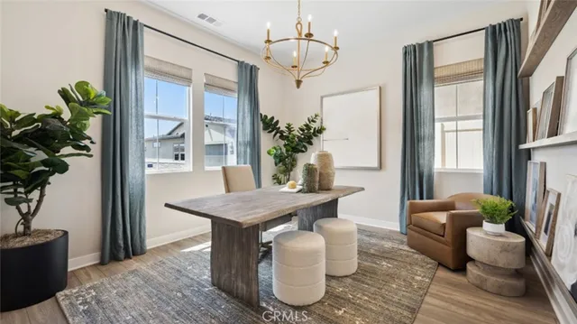 a dining room with furniture potted plants and wooden floor