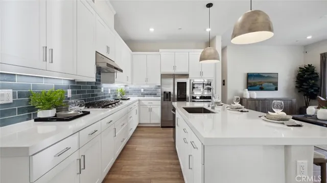 a kitchen with stainless steel appliances kitchen island granite countertop a sink a stove and cabinets